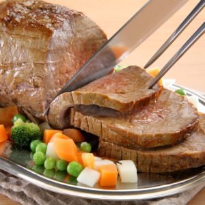 Sliced roast beef with broccoli, carrots and peas