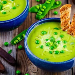 Green pea soup on wooden rustic background